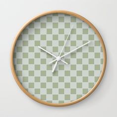 a green and white checkered wall clock with wooden frame on the front of it