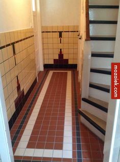 an empty hallway with tiled floors and stairs