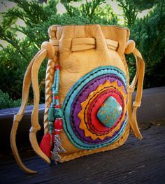 a small purse with braids and beads on the handle is sitting on a wooden table