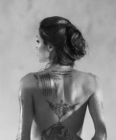 the back of a woman with tattoos on her body