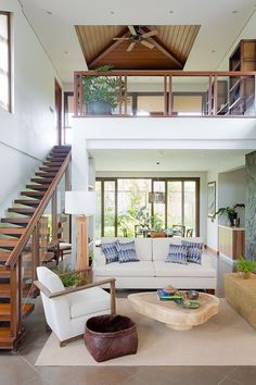 a living room filled with furniture and a stair case