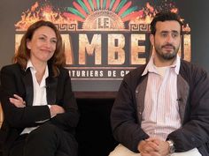 two people sitting next to each other in front of a sign that says limbberi