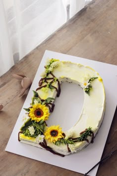 a cake with sunflowers on it sitting on top of a white paper sheet