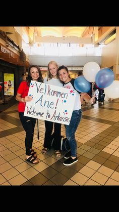 three girls holding up a sign that says women are welcome to advancess in front of them