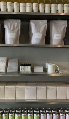 the shelves are filled with different types of coffees and tea bags on display in front of them