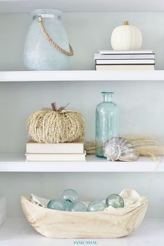 three shelves filled with books and vases on top of them