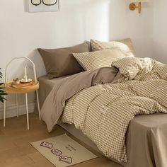 a bed sitting in a bedroom next to a table with a potted plant on it