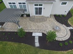 an aerial view of a large house with landscaping and patio area in the foreground