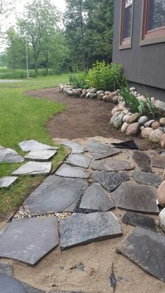 a stone walkway in front of a house