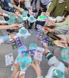 a group of people holding onto small boxes with bows on them and ribbons around them