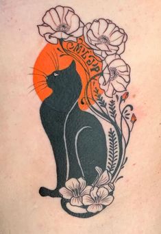 a black cat sitting on top of a woman's back with flowers around it