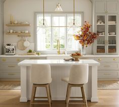 two stools sit at the center of a kitchen island in front of a window