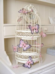 a white birdcage with pink butterflies on it