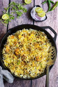 a pan filled with rice and vegetables on top of a wooden table