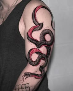 a man with a tattoo on his arm has a red and black snake tattooed on it