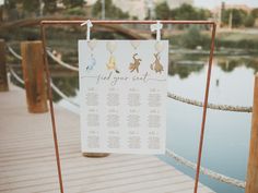 a sign that is on the side of a wooden dock with balloons attached to it