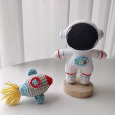 two crocheted toys sitting on top of a white table next to each other