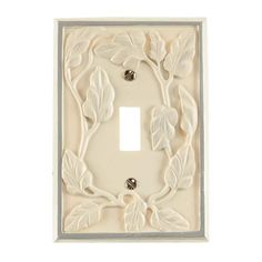 a white light switch cover with leaves on it