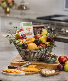 a basket filled with fruit and cheese on top of a counter next to an oven