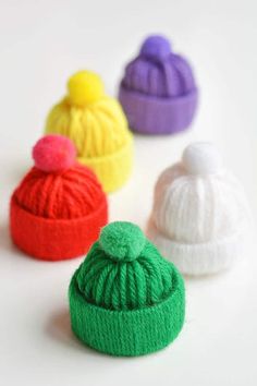 four knitted beanies sitting next to each other