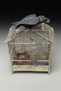 a small bird in a cage on top of a table