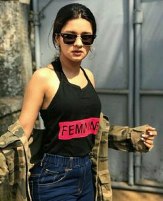 a woman in black shirt and camo jacket with pink lettering on her tank top