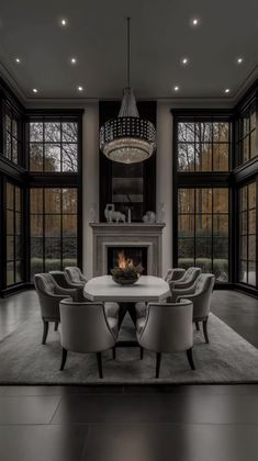 an elegant dining room with large windows and a fire place in the middle of the room