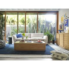 a living room filled with furniture and plants