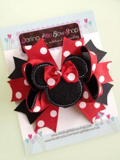 a red and black minnie mouse bow with polka dots on the bottom is attached to a card