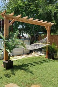 a backyard with a hammock and potted plants