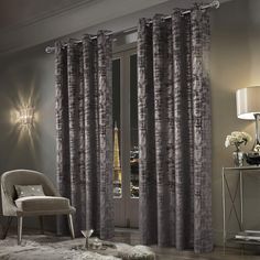 an elegant living room with grey walls and white carpeted flooring, two windows covered in curtains