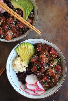 two bowls filled with meat, rice and veggies next to chopsticks