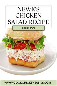 a chicken salad sandwich with lettuce and tomatoes on it is sitting on a white plate