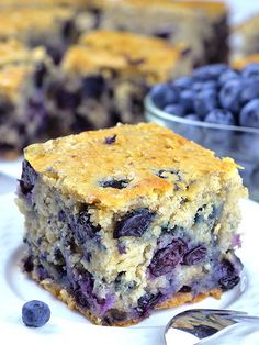 a close up of a plate of food with blueberries and cake in the background