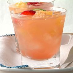 two glasses filled with drinks sitting on top of a white plate next to each other