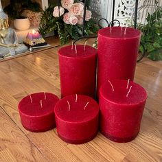 four red candles sitting on top of a wooden table