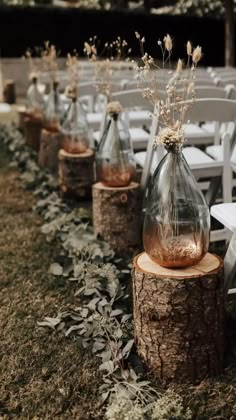 an image of a wedding ceremony with flowers in vases on the side of a tree stump