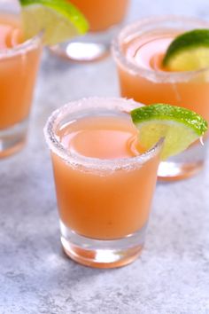 three glasses filled with orange and lime margaritas