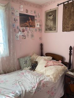 a bedroom with pink walls and pictures on the wall