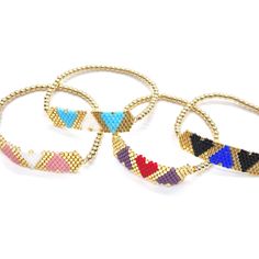 four pairs of bracelets with different colors and designs on each one, all in gold