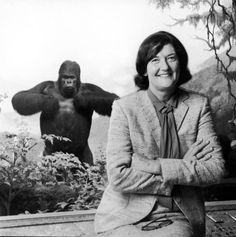 an old black and white photo of a woman sitting next to a gorilla