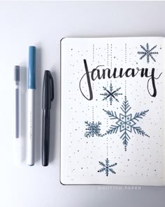 a notebook with the word january written on it next to two markers and a pen