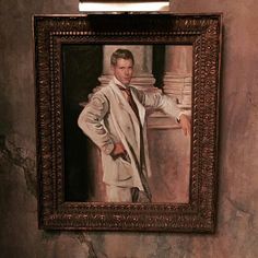 a painting of a man in a white suit and tie is hanging on the wall