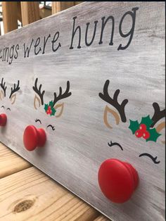 a wooden sign with reindeer noses and holly berries on it that says, merry things were hung