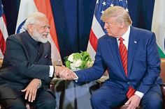 two men shaking hands in front of flags