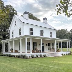 a large white house sitting on top of a lush green field