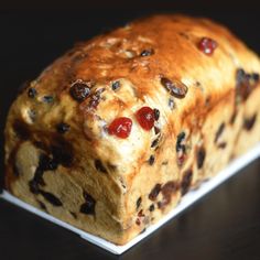 a loaf of bread with raisins and cherries on it