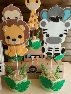 some cupcakes that have animals on top of them and grass in the middle