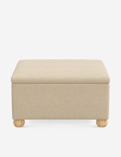 an upholstered footstool with wooden legs and a beige fabric seat cover