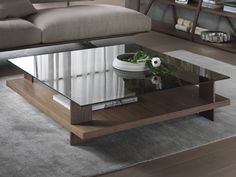 a glass coffee table sitting on top of a wooden floor